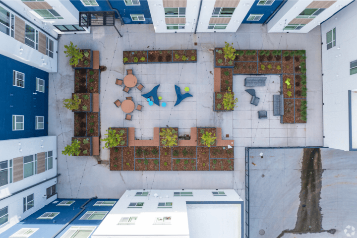 mixed-use housing the rose on colfax courtyard aerial — Credit: Apartments.com