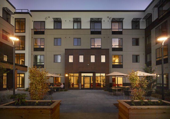 Laurel at Perennial Park, affordable housing architect, courtyard entrance at dusk — VMWP